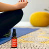 bottle of Nano Ojas spray with a woman meditating